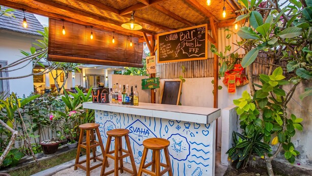 An outdoor bar with wooden stools, a chalkboard menu, and various bottles. - Svaha Private Villas Ceningan (Ceningan Island)