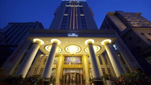 Una entrada de hotel con una fachada imponente, amplias columnas y un letrero destacado.