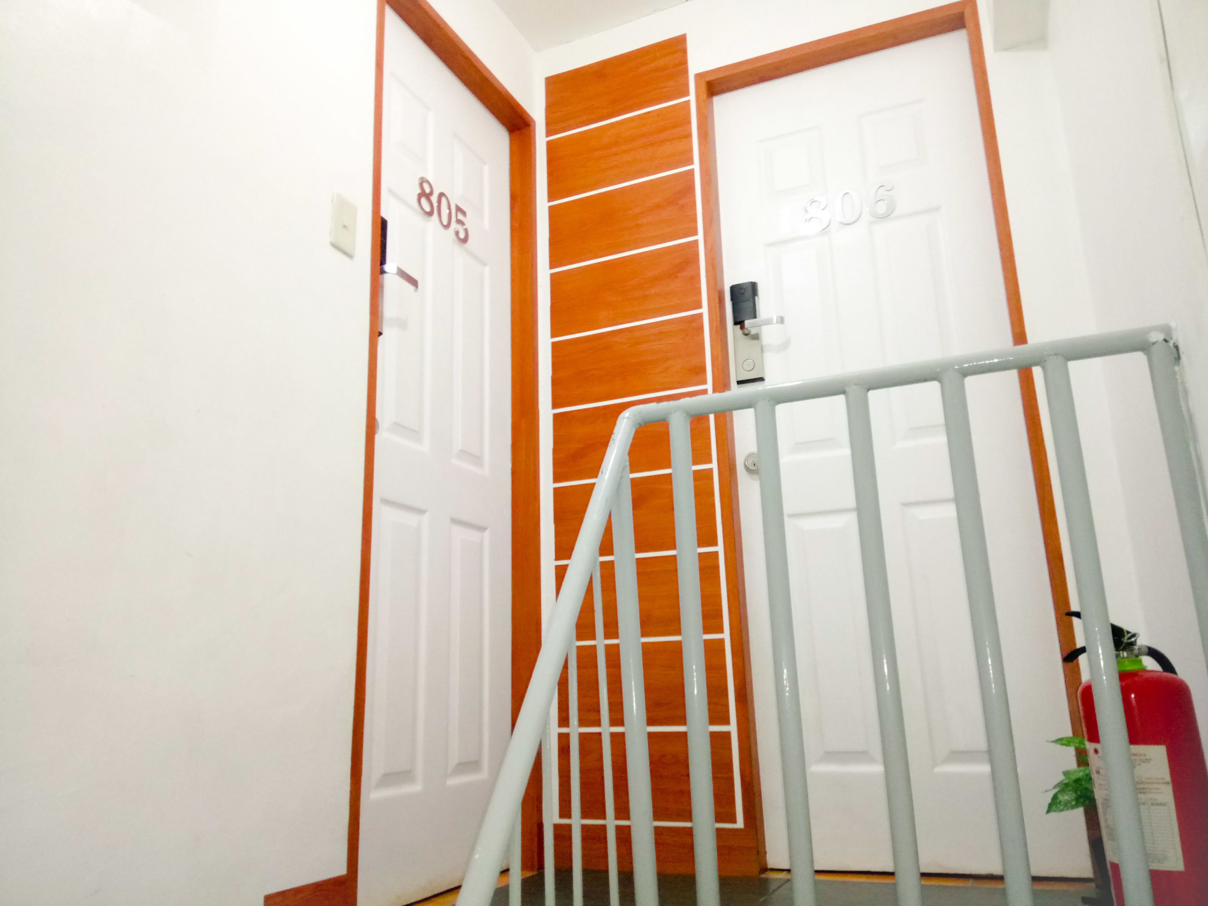 A hallway with two doors, one labeled 805 and the other 806, and a metal railing in the foreground.