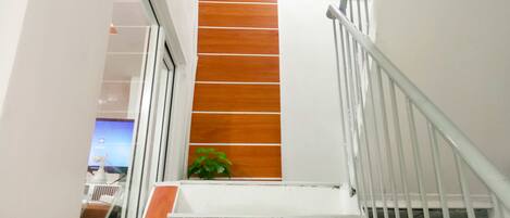 A staircase with white railings and wooden steps leading to a lower level.