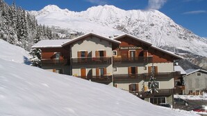 A multi-story building with a sign reading "Meublé ROSALINA" in a snowy mountainous area. - Meublè Rosalpina (Valdidentro)