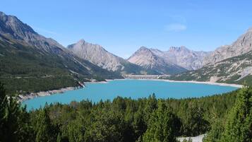 A mountainous landscape with a large turquoise lake and a dam in the distance.