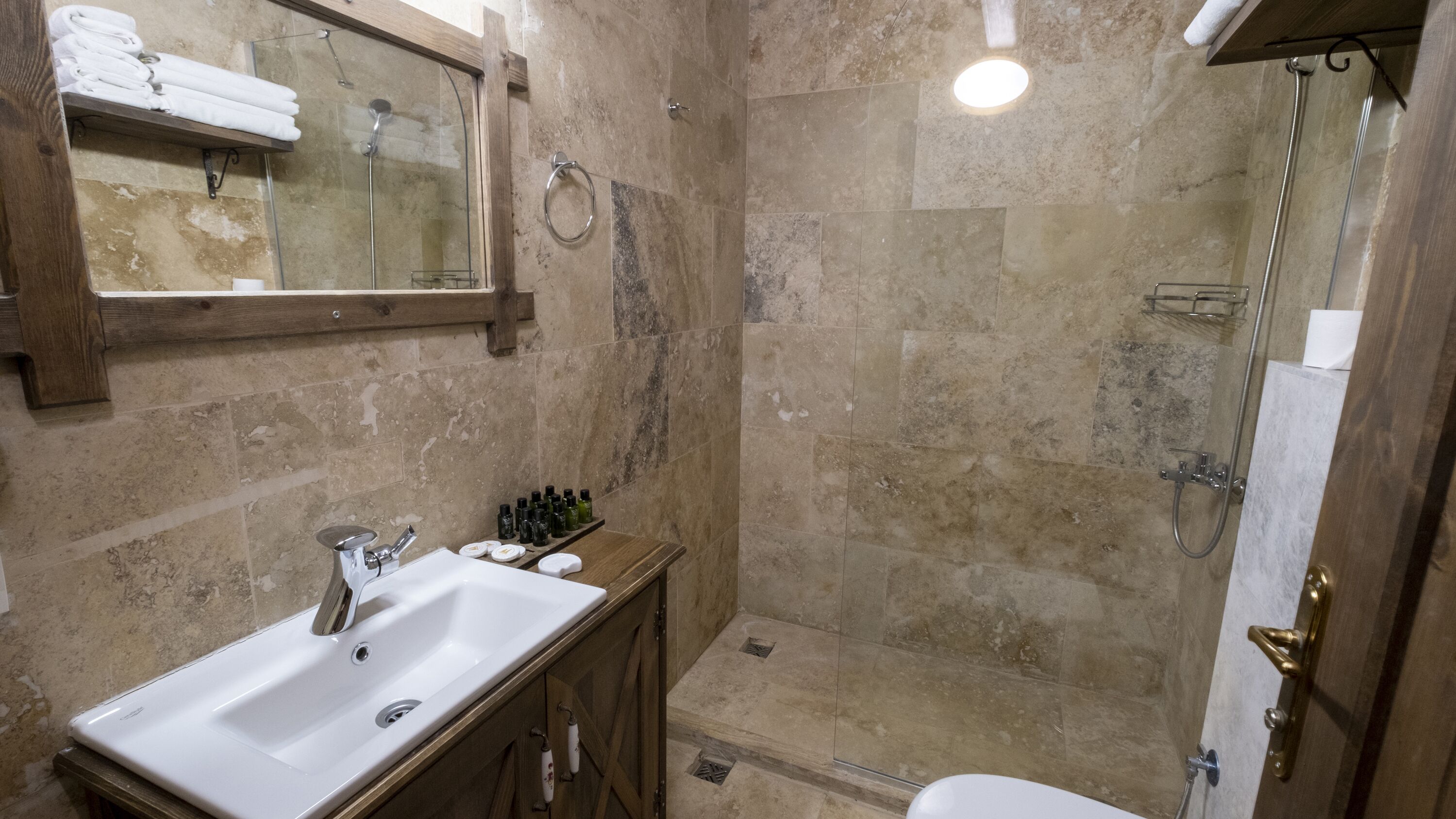 A bathroom with a sink, mirror, and shower.