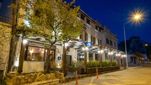 Un edificio histórico con una zona de estar al aire libre techada, paredes de piedra y un farol.