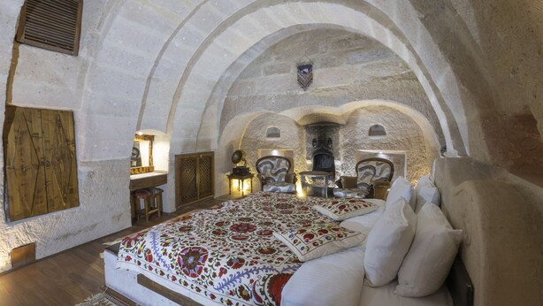 Una habitación con una cama grande, un escritorio y una chimenea.