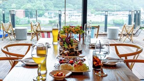 A dining table with a variety of dishes, drinks, and a view of the outdoors. - Cheonjiyeon Crystal Hotel (Seogwipo)