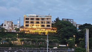A multi-story building with a sign indicating it is a hotel. - Cheonjiyeon Crystal Hotel (Seogwipo)