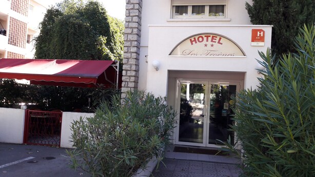A hotel entrance with a red awning, a sign reading "HOTEL Les Trois Vigneaux," and a glass door. - Hôtel les Troenes (Montpellier)