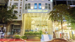 Un hotel de varios pisos con letreros iluminados que dicen "GOLDEN LIGHT".