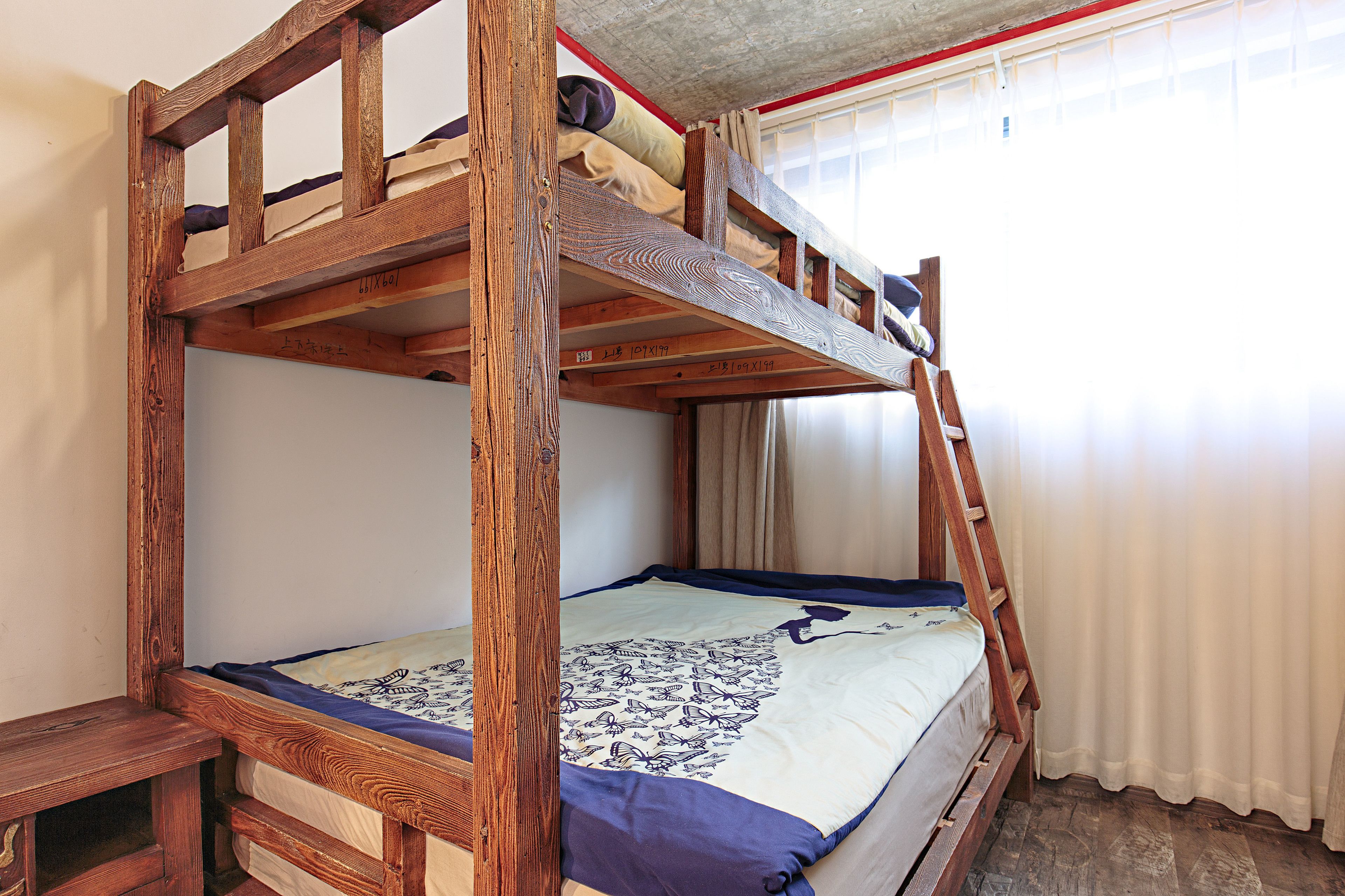Un lit superposé avec une structure en bois et une couvre-lit à motifs.
