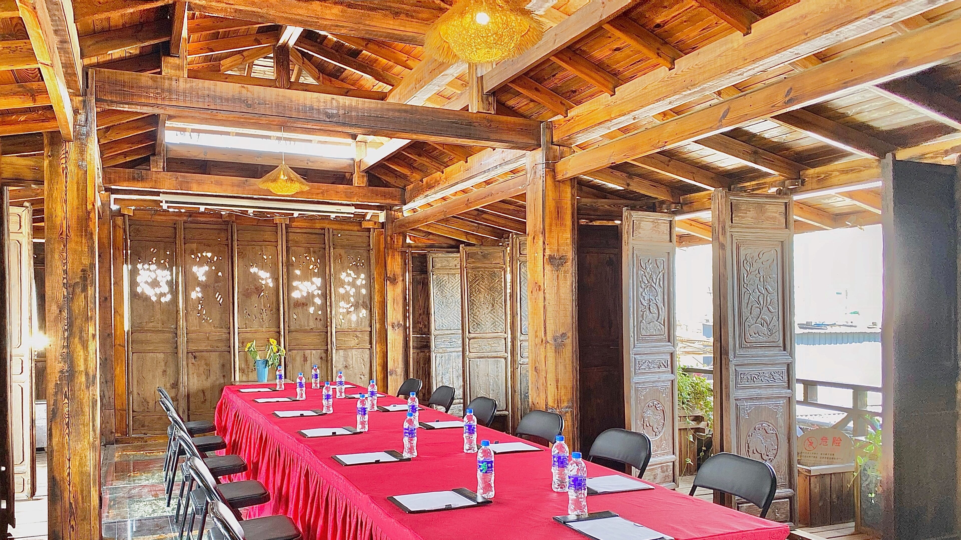 Un salón de conferencias con una larga mesa, sillas y botellas de agua.