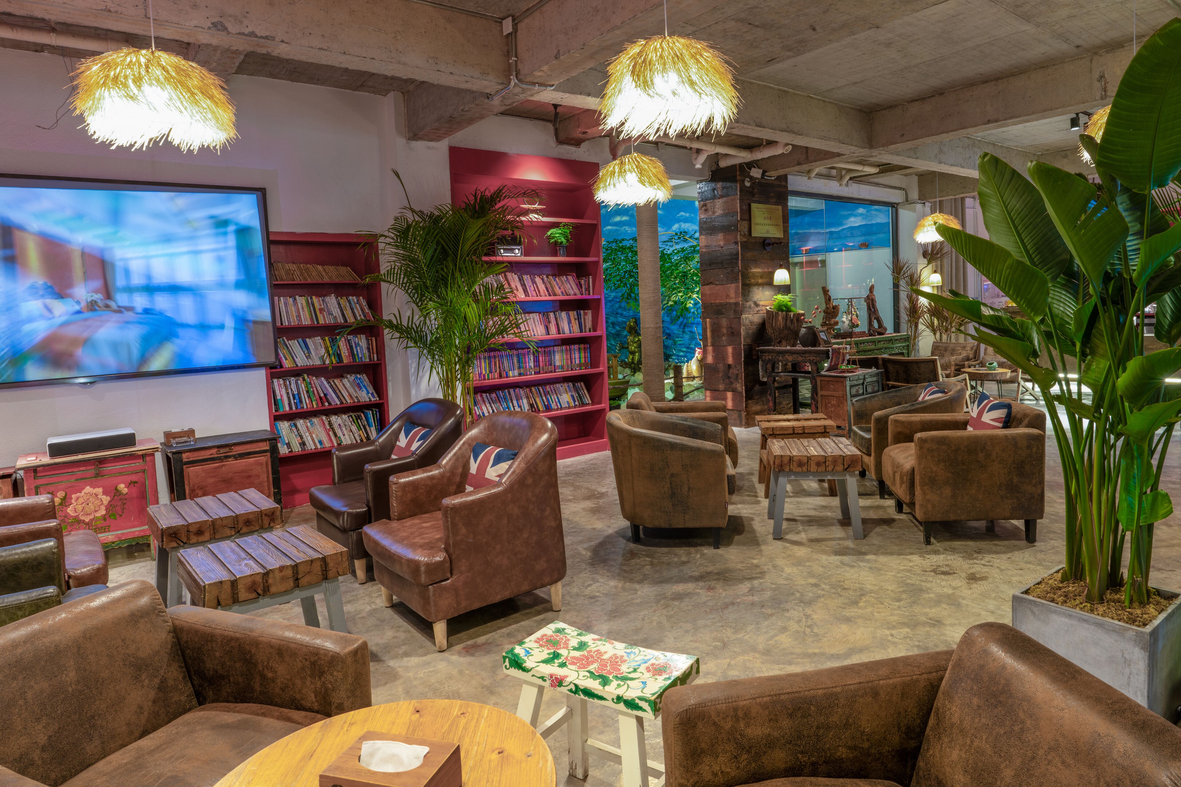 A cozy lounge area with leather sofas, a bookshelf, and a television.