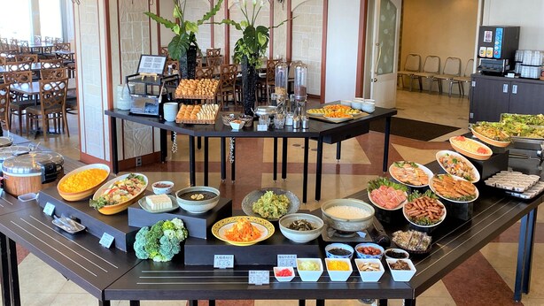 A buffet setup with various food items and a seating area with chairs. - Nansei Kanko Hotel (Naha)