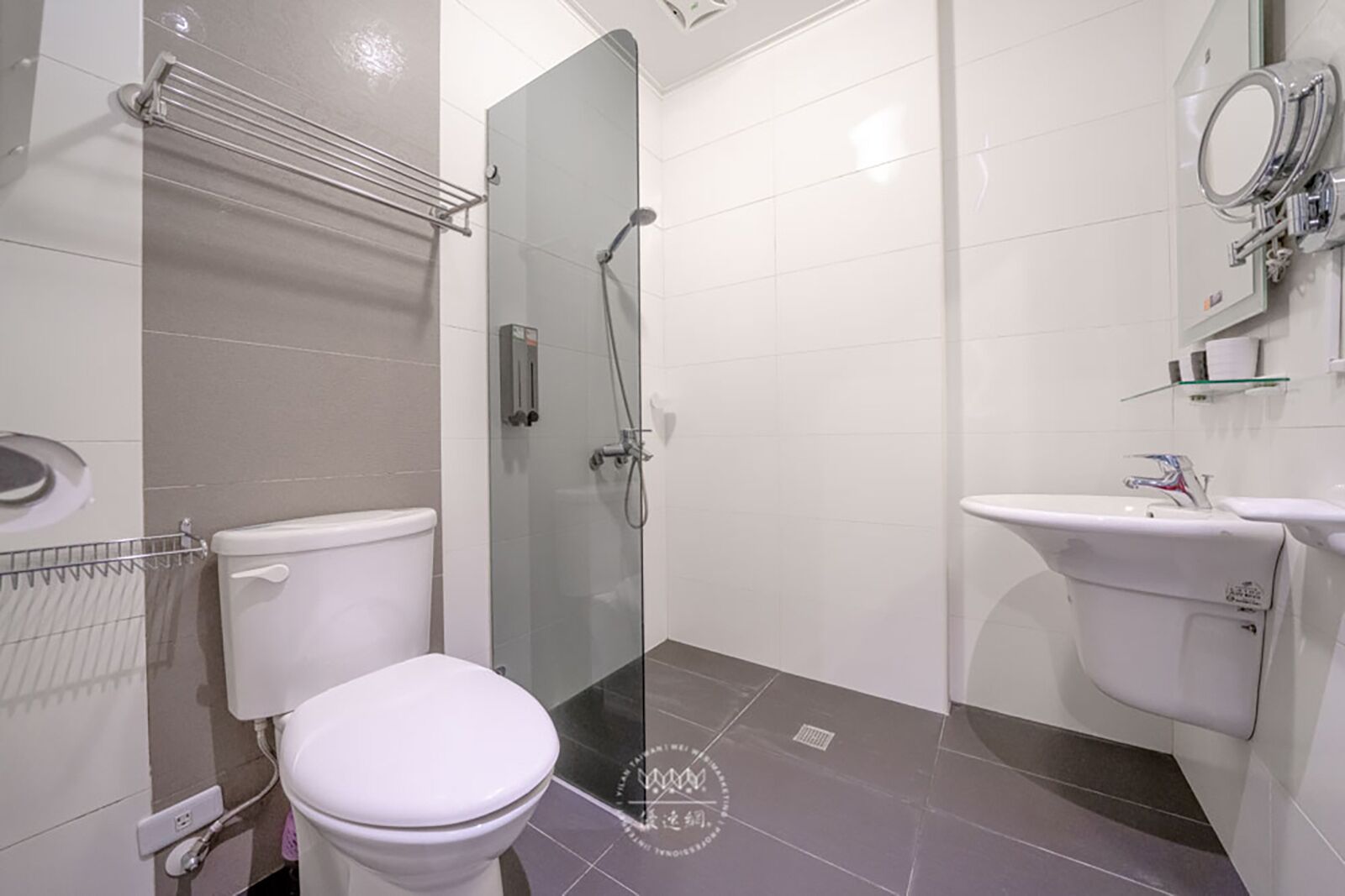 A modern bathroom with a toilet, shower, and sink.