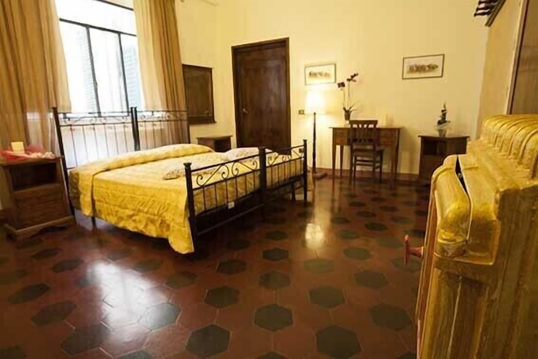 A room with a bed, a desk, a chair, and a sofa.