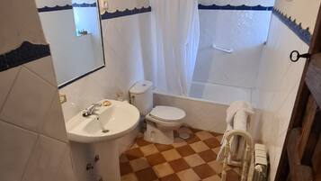 Een badkamer met een wastafel, toilet en bad.