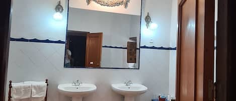 Un baño con dos lavamanos, un espejo y una puerta de madera.