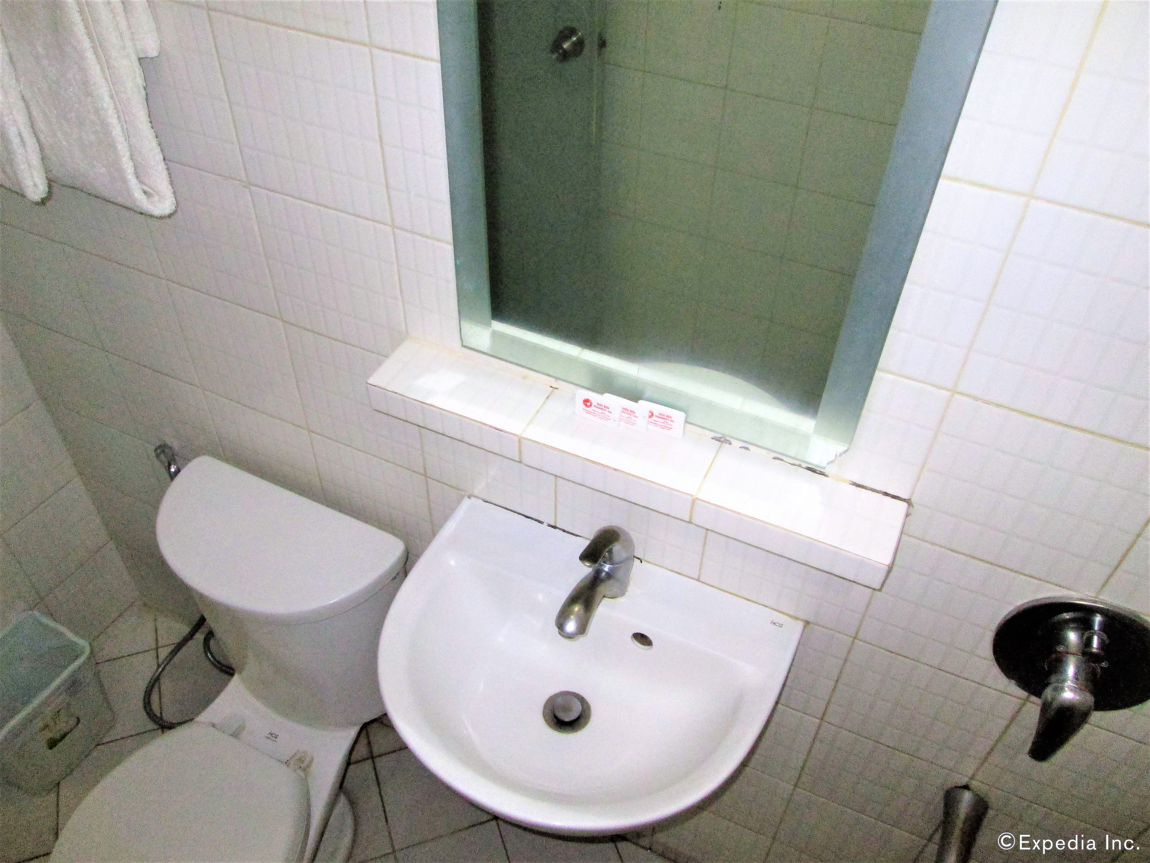 Un baño con inodoro, lavamanos y cabina de ducha de vidrio.