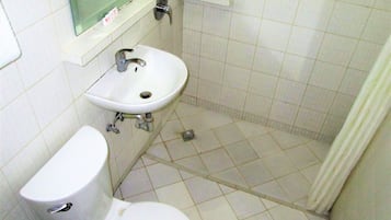 Un baño con inodoro, lavamanos y ducha.