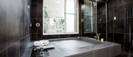 Une salle de bain moderne avec une grande baignoire, une douche en verre et une vue sur un balcon.