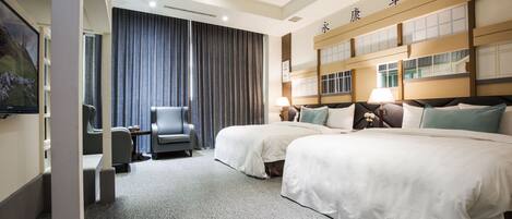 Ein Hotelzimmer mit zwei Betten, einem Schreibtisch und einem Stuhl.