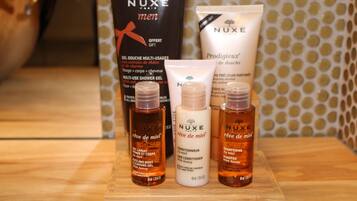 A selection of Nuxe Paris skincare products on a wooden surface.