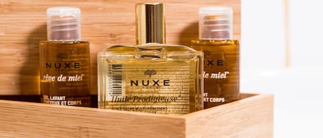 Una caja de madera con tres botellas de perfume NUXE.