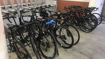 A bicycle parking area with multiple bikes secured to a rack.
