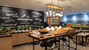 A breakfast buffet with various food items and a blackboard with text and images. - Cocoon München Hauptbahnhof (Munich)