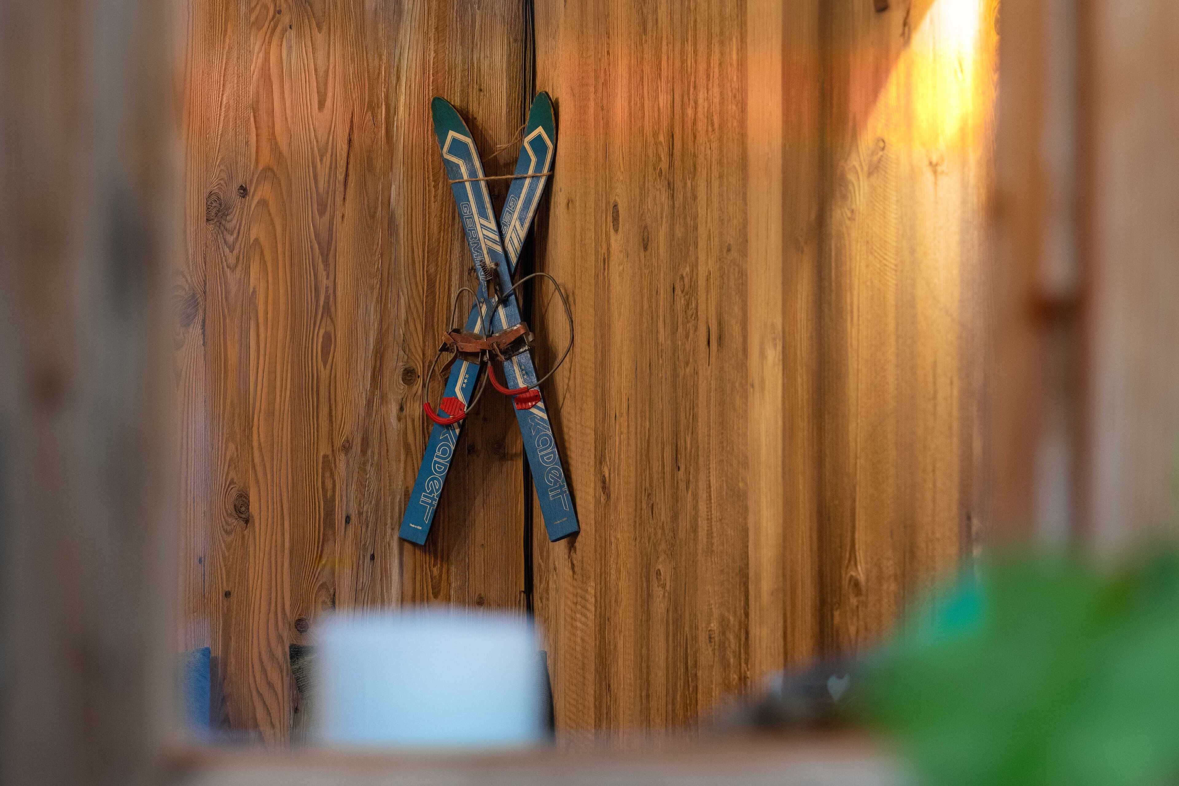 A pair of skis tied to a wooden wall.