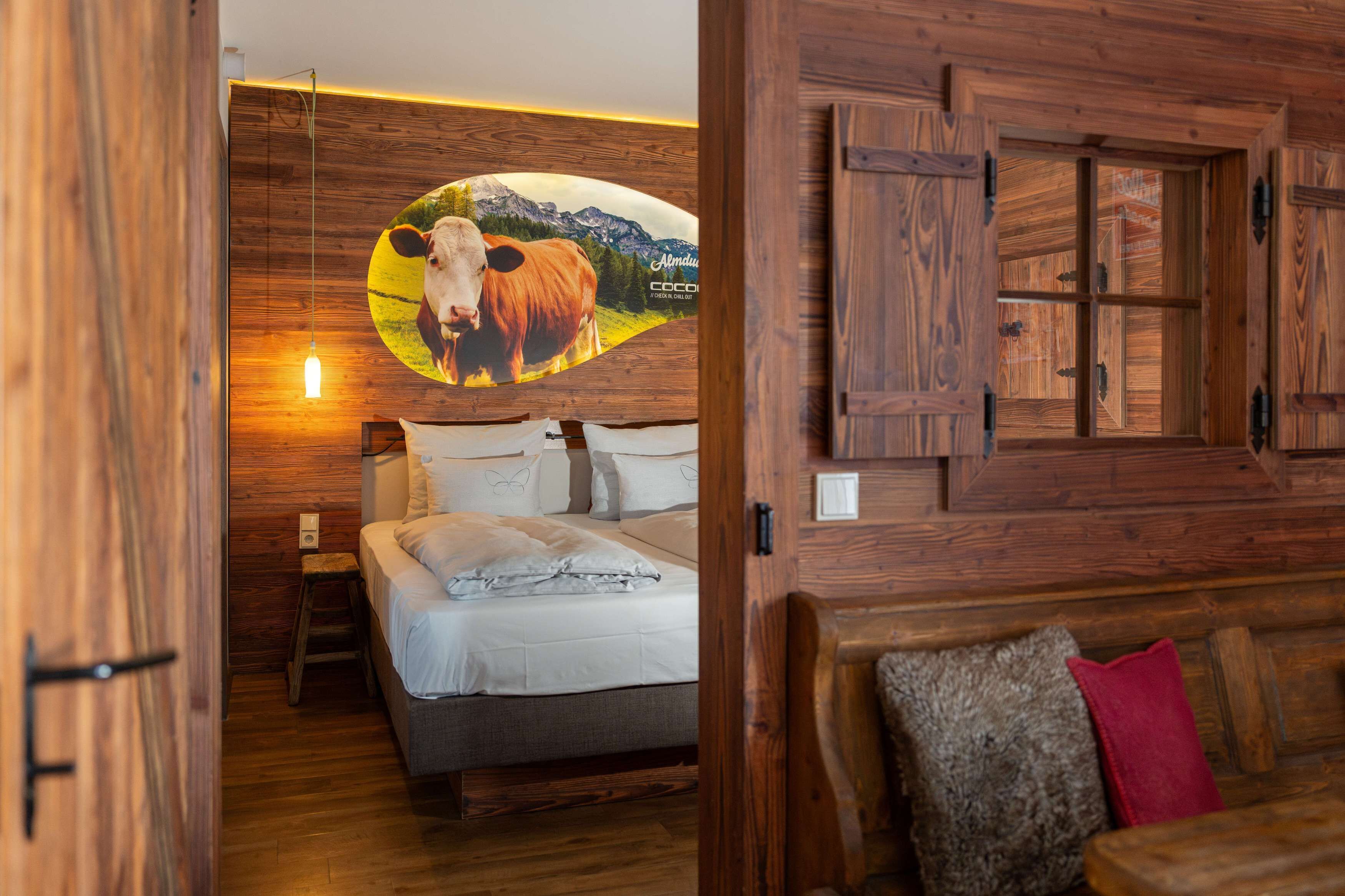 A wooden-finished bedroom with a bed, pillows, and a nightstand.