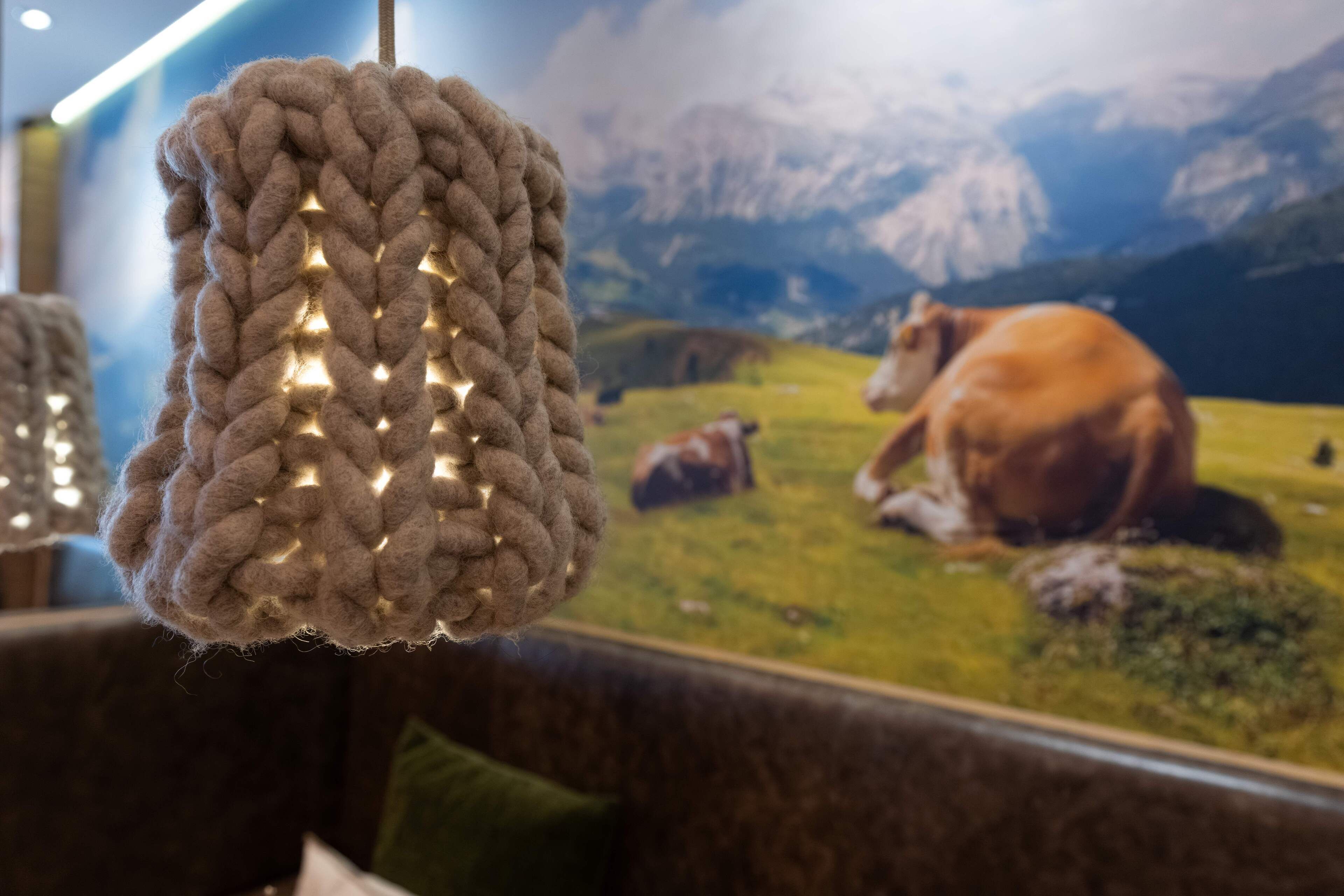 A knitted item with a textured pattern and a backdrop of a landscape with cows.
