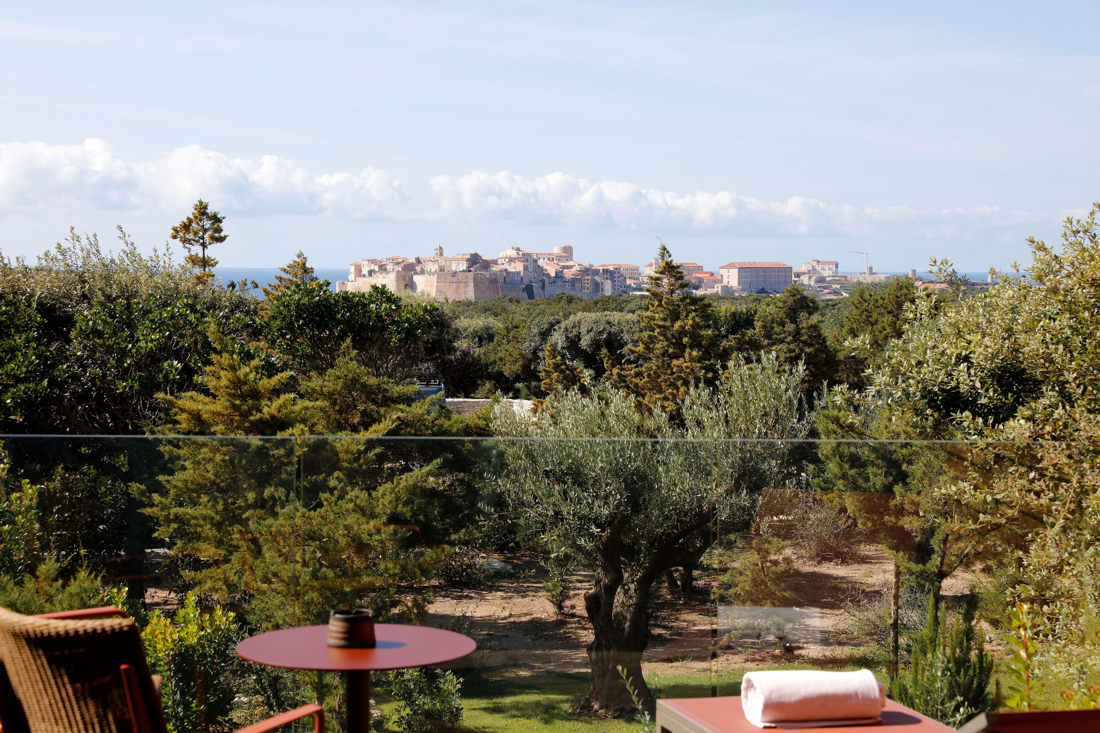 A balcony with a view of a historic cityscape, including a prominent castle-like structure.