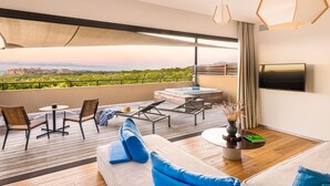 Un balcon moderne doté d’un jacuzzi, de chaises longues et d’un téléviseur.