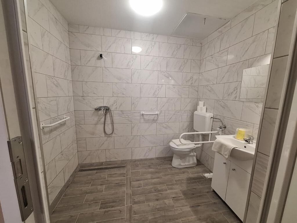 Un baño con ducha, inodoro y lavabo.