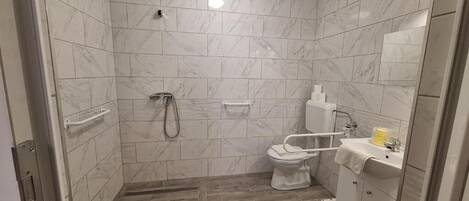 Un baño con ducha, inodoro y lavabo.