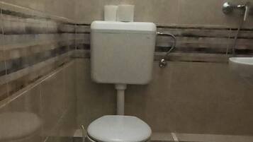 Ein kleines, modernes Badezimmer mit Toilette, Bidet und Dusche.