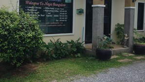 A bungalow with a signboard listing services like laundry, restaurant, and rental. - Naya Pool Villa (Rawai)