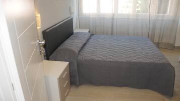Una camera da letto con un letto, un comodino e una cassettiera.