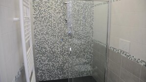 A shower with mosaic tile walls and a white radiator. - La Perla Affittacamere (La Spezia)