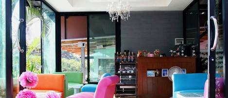 Un interior moderno con zona de bar, asientos y una araña.