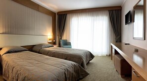 A hotel room with two beds, a desk, a chair, and a TV. - Buyuk Anadolu Eregli Hotel (Karadeniz Eregli)
