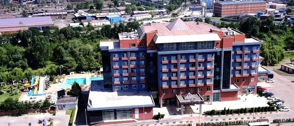 A multi-story hotel with a red and blue facade, a swimming pool, and a parking area. - Buyuk Anadolu Eregli Hotel (Karadeniz Eregli)