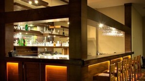 A bar area with a counter, shelves with bottles, and bar stools. - Buyuk Anadolu Eregli Hotel (Karadeniz Eregli)
