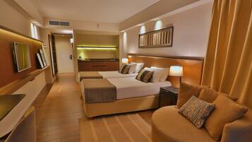 A hotel room with two beds, a sofa, a desk, and a mirror.