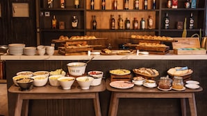 Un bufé de desayuno con diversos alimentos y una selección de bebidas.