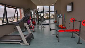 A gym with treadmills, weight machines, and a bench.
