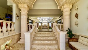 A grand staircase with white columns and a view to a balcony. - Cielo Maya Beach Tulum (Tulum)