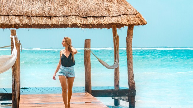 A wooden pier leading to a thatched-roof structure by the ocean. - Cielo Maya Beach Tulum (Tulum)