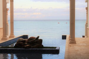 Un espace piscine agrémenté d’une sculpture de tortue, avec une eau cristalline et une vue sur la mer.